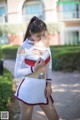 A woman in a white and red outfit is posing for a picture.