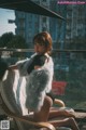 A woman sitting on a chair with a fur coat over her shoulder.