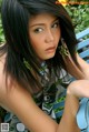 A woman sitting on a blue bench in a park.
