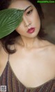 A woman with a green leaf on her head.