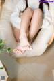 A woman sitting in a chair with her feet up.