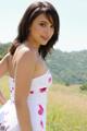 A woman in a white dress standing in a field.