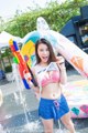 A woman in a bikini holding a water gun.