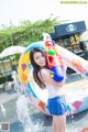 A young woman holding a water gun in a water park.