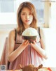 A woman holding a bowl of rice in front of a window.