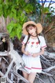 A woman in a straw hat is posing for a picture.