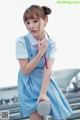 A woman in a blue dress holding a red umbrella.