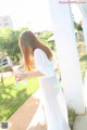 A woman in a white dress holding a water bottle.