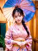 A woman in a pink kimono holding an umbrella.