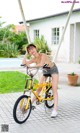 A woman in a bikini sitting on a yellow bike.