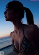 A woman in a bikini standing on a beach.