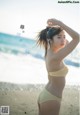 A woman in a bikini standing on a beach.