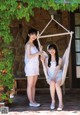 Two young women sitting in a hammock on a patio.