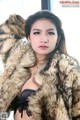 A woman in a fur coat posing for a picture.