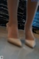 A close up of a woman's legs in a pair of shoes.