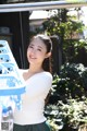 A woman standing next to a blue laundry basket.